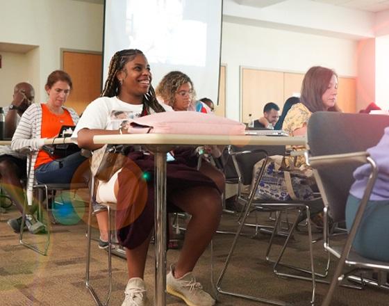 students in a graduate program class laughing and smiling